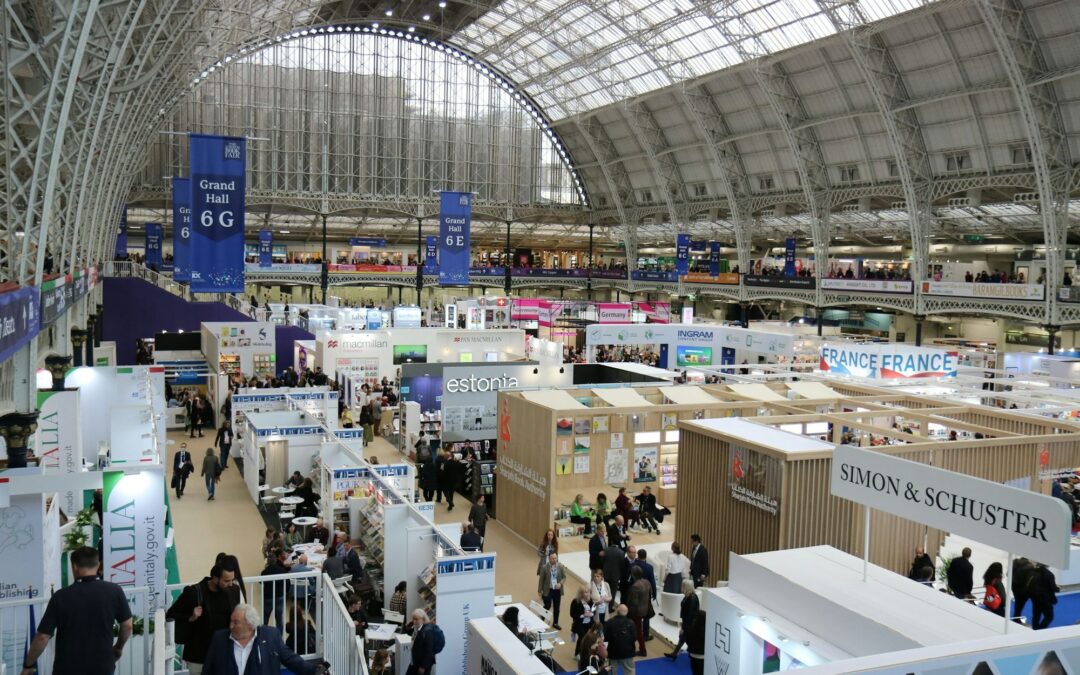 Crowded exhibition hall under a glass roof