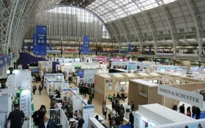Crowded exhibition hall under a glass roof