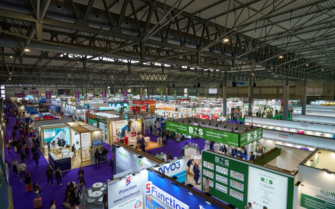 Busy exhibition hall with rows of trade show booths