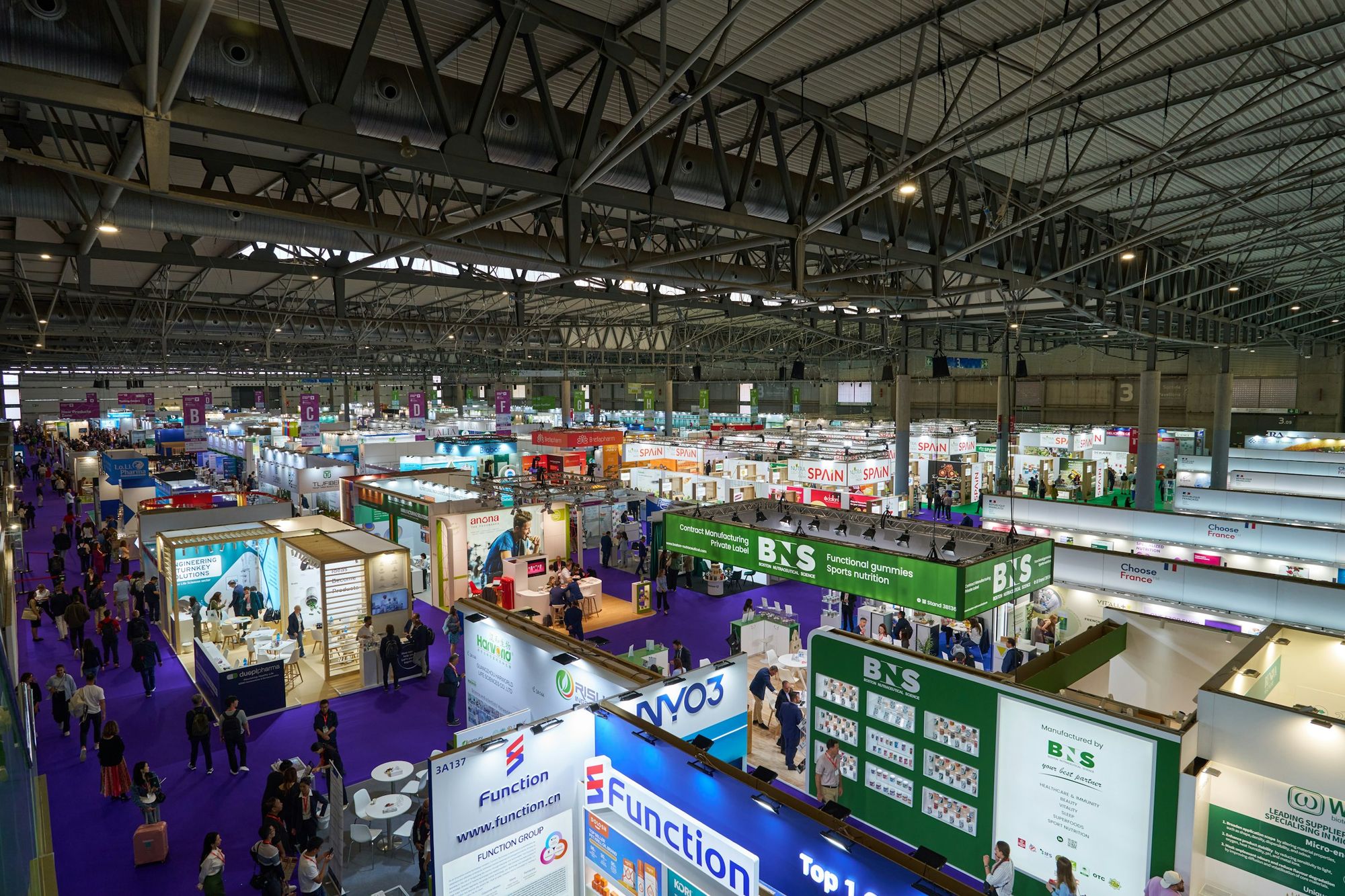 Busy exhibition hall with rows of trade show booths