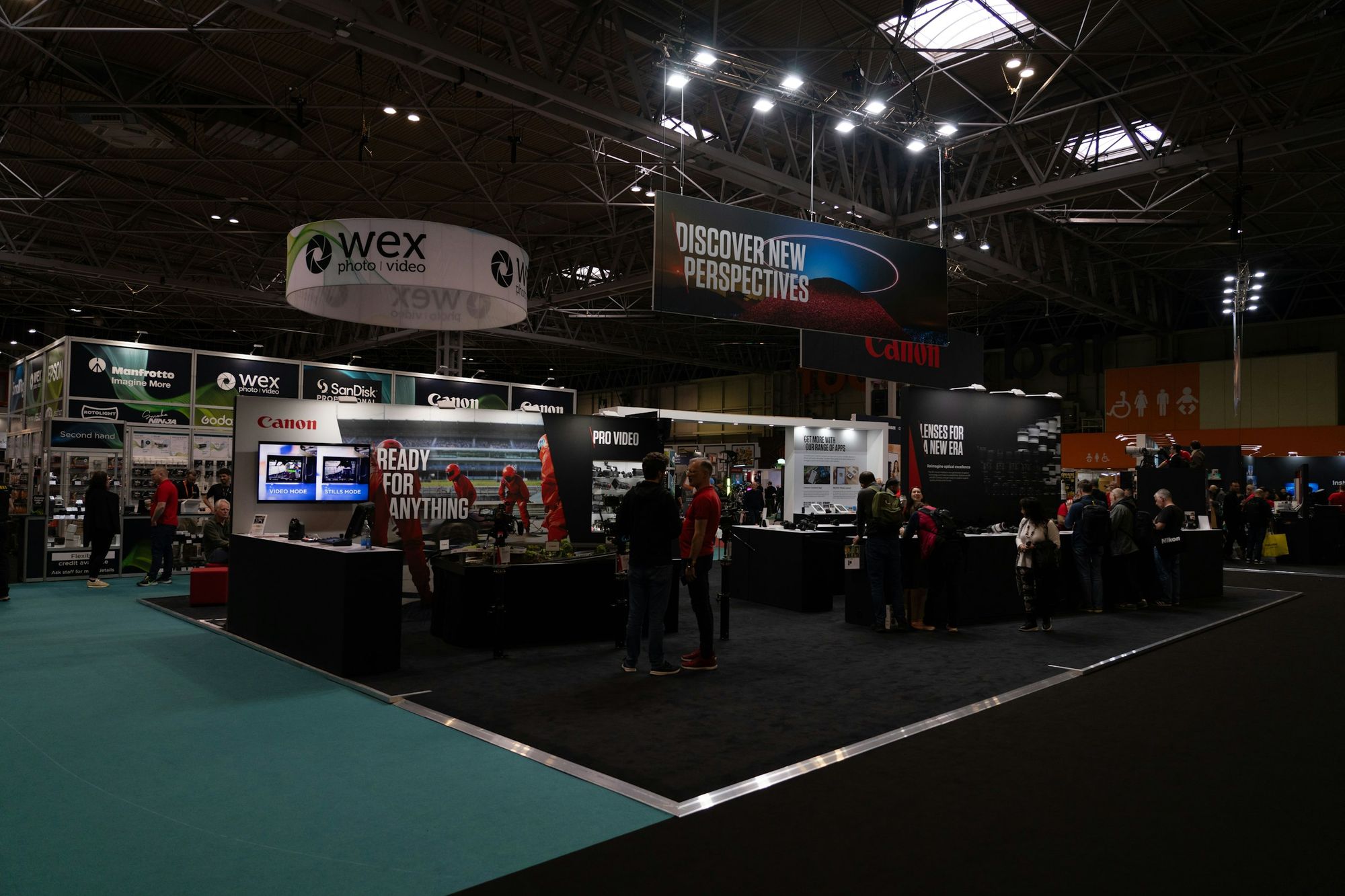 Lit trade show booths on a dark exhibit floor